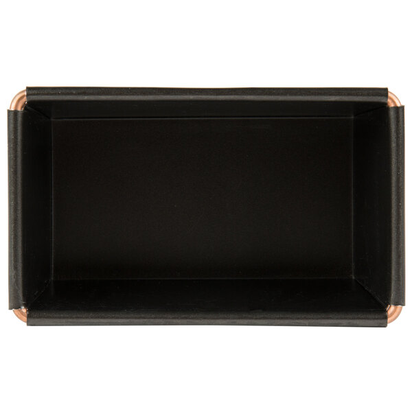 A black rectangular loaf pan with copper corners.