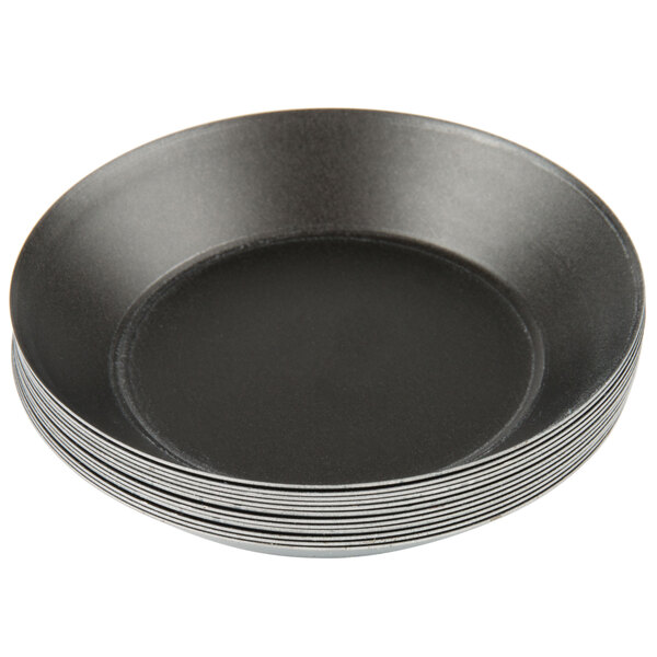A stack of black Matfer Bourgeat tartlet/quiche molds.
