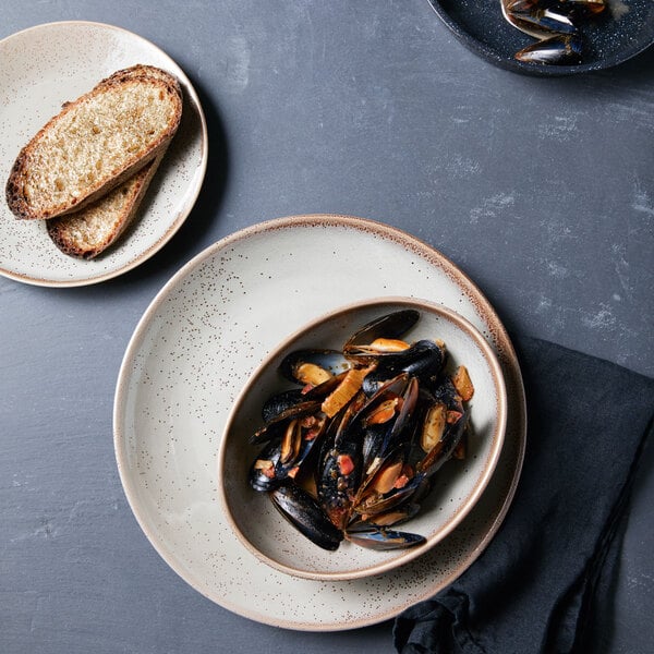 A plate of mussels and toast on a Oneida Terra Verde Natural porcelain plate.