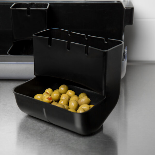 A Tablecraft black replacement container filled with green olives on a counter.