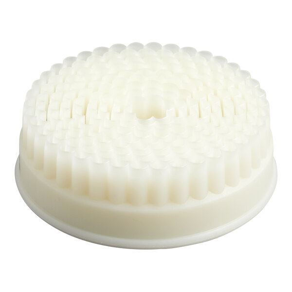 A round, white, plastic object with a fluted, textured surface and a flat base.