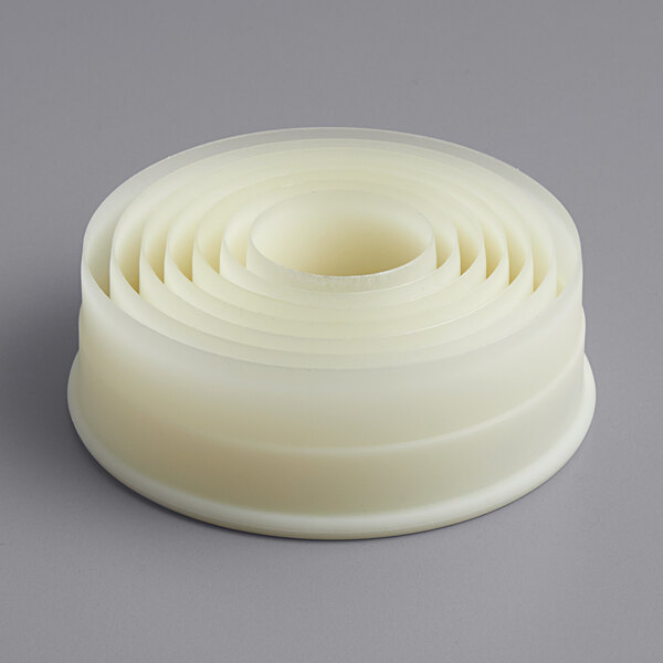 A white Matfer Bourgeat Exoglass ring with six circular cutters inside.