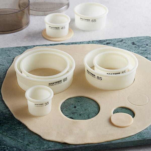 A white container with black text containing white Matfer Bourgeat dough cutters.