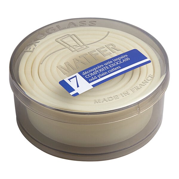A round, transparent container holding a nested set of seven cream-colored circular cutters with a labeled lid.