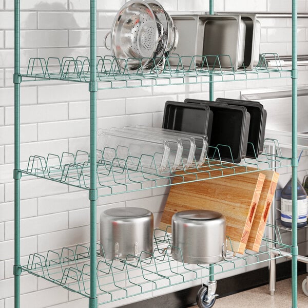 A Regency green epoxy wire drying rack shelf with pots and pans on it.