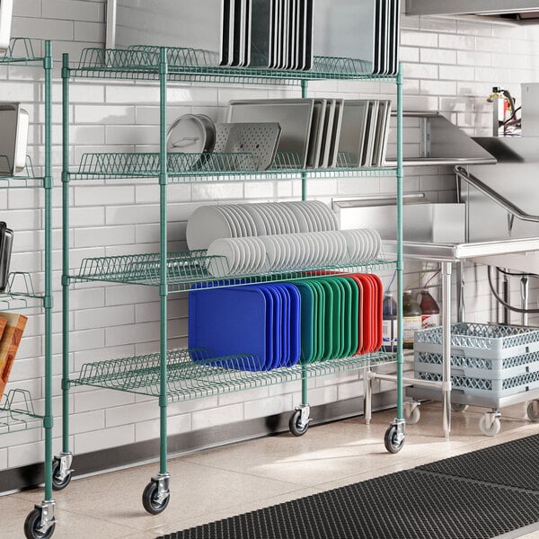A metal rack with green epoxy shelves holding dishes.