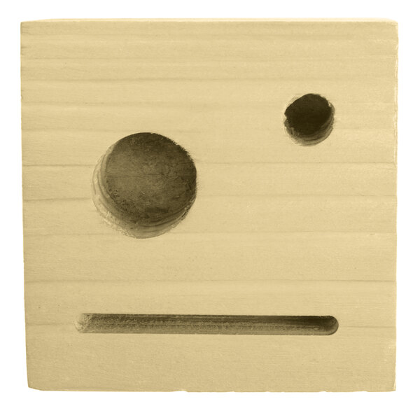 A natural wood block with two holes in it.