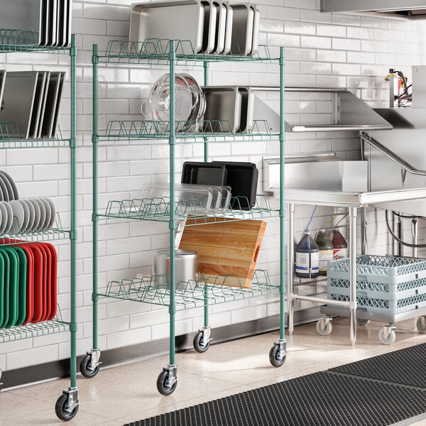 A kitchen with a green metal wire rack holding trays.