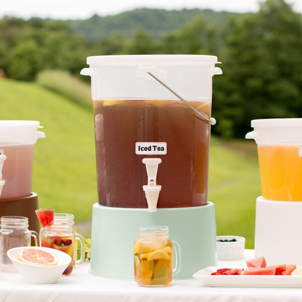 A Choice translucent plastic beverage dispenser with cucumber base filled with a drink and lemon slices.