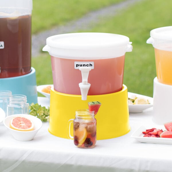 A white Choice beverage dispenser with a yellow base on a table with different colored drinks.