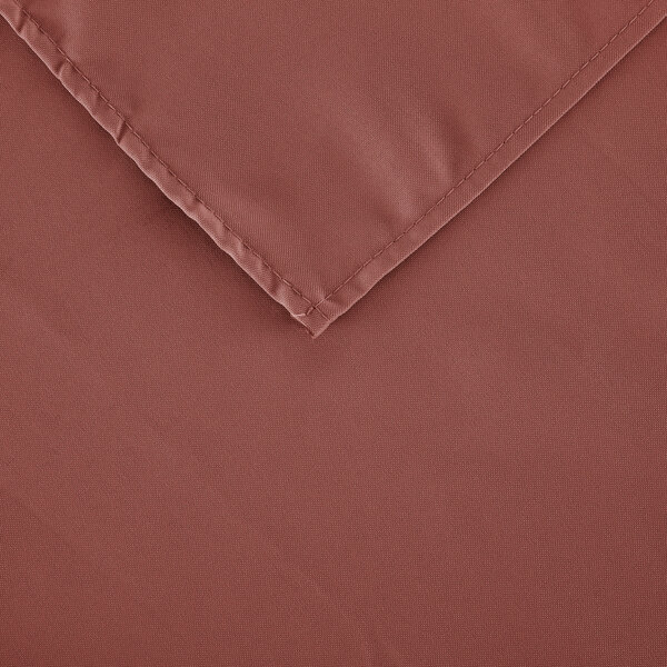 A close-up of a mauve square cloth table cover with a corner.