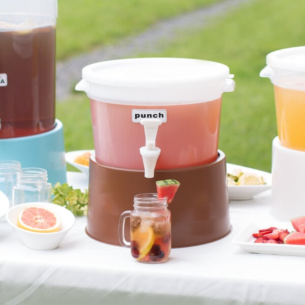 A white Choice beverage dispenser with a brown base on a table with drinks.