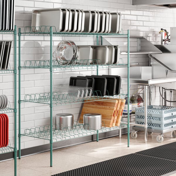 A kitchen with a Regency green epoxy drying rack holding baking pans.