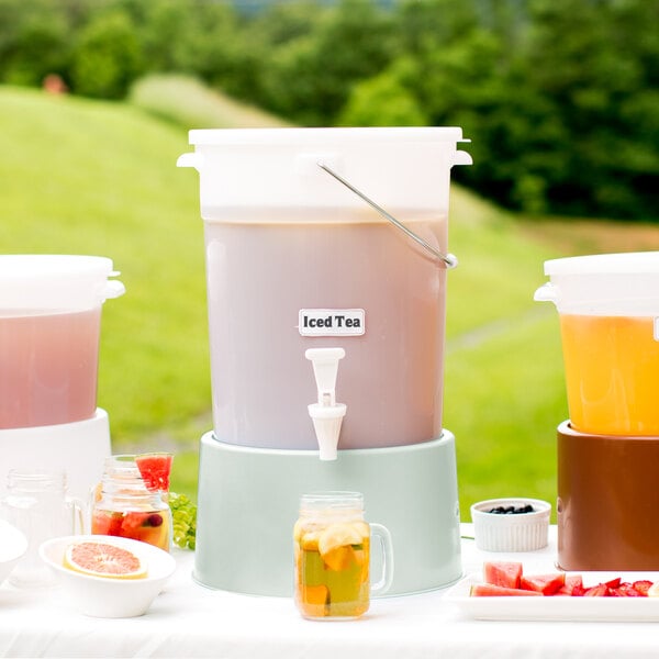 A white Choice plastic beverage dispenser with cucumber base filled with a drink and lemon slices.