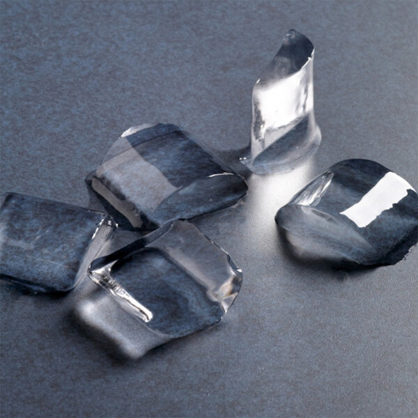 A group of Hoshizaki crescent ice cubes on a grey surface.