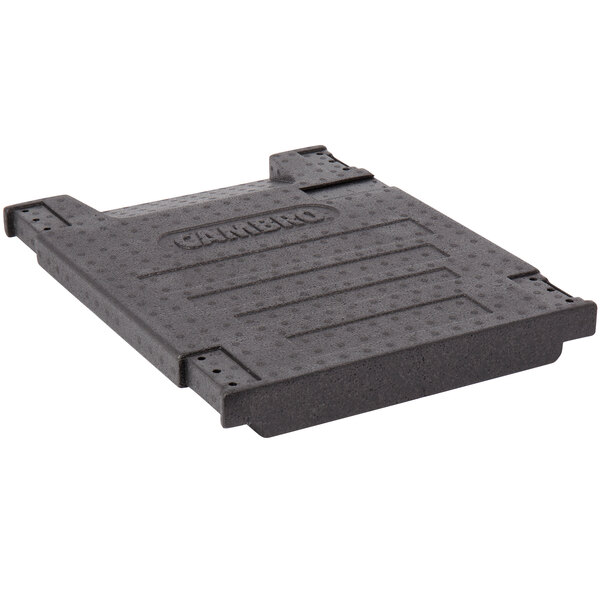 A black plastic rectangular cover with text and holes.