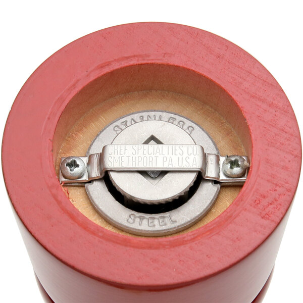 A red metal Chef Specialties pepper mill with a metal lid.