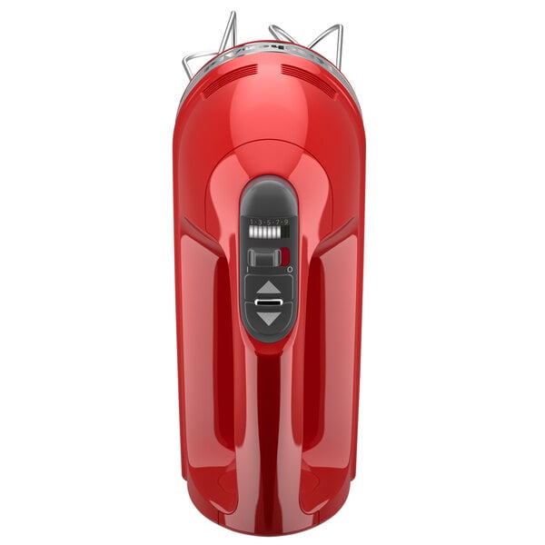 A red KitchenAid electric hand mixer with steel attachments.