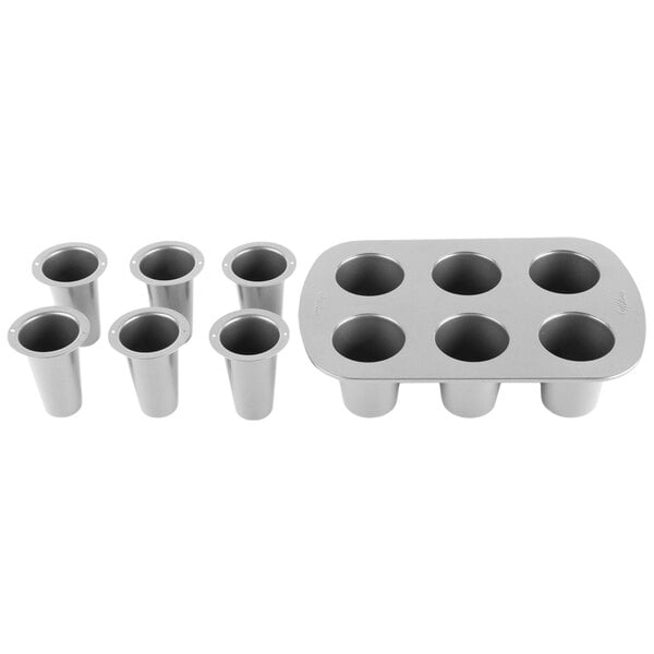 A silver Wilton shot glass baking mold with six cylinders.