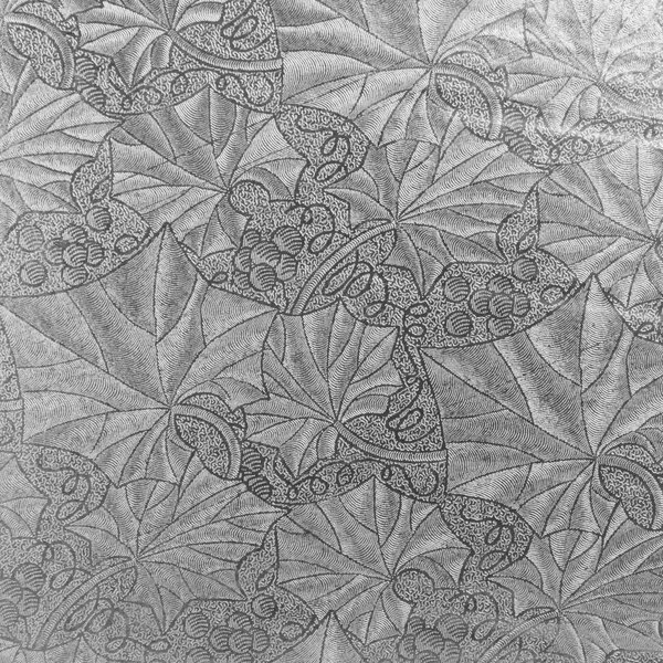 A white round cake drum with a quilted pattern on top.