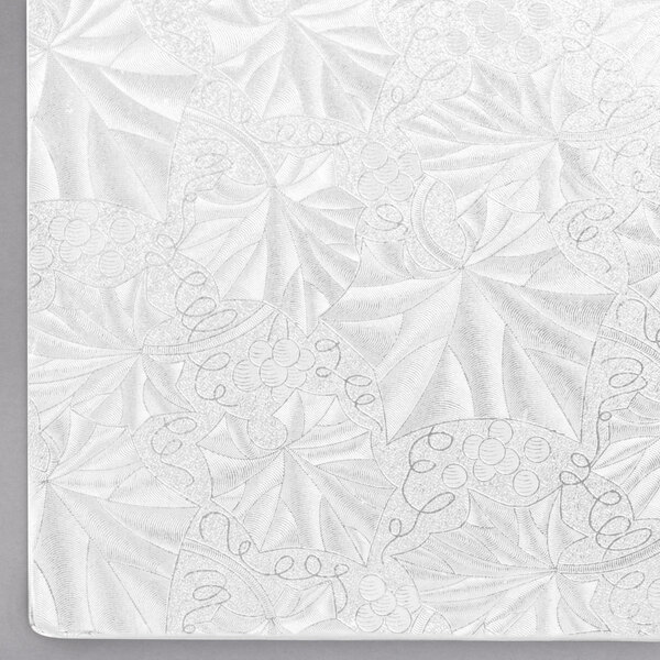 A white square cake drum with a patterned surface.