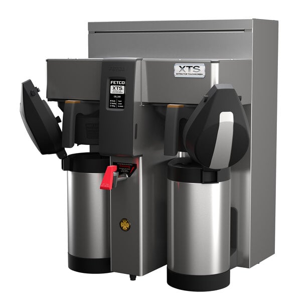 A Fetco stainless steel coffee brewer with two black and silver containers on top.