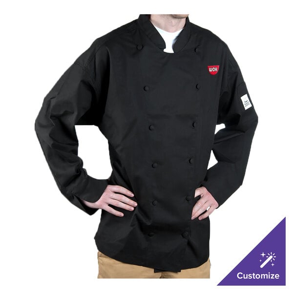 A man wearing a black Chef Revival chef coat with his hands on his hips.