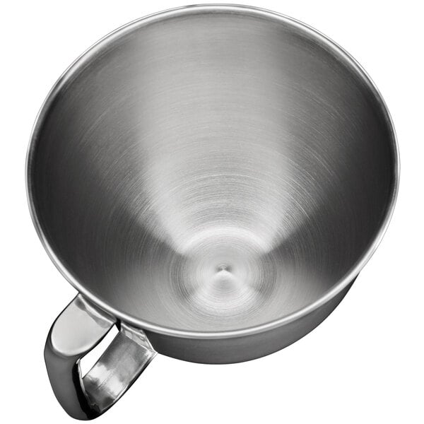 A close-up of a silver stainless steel KitchenAid mixing bowl with a handle.