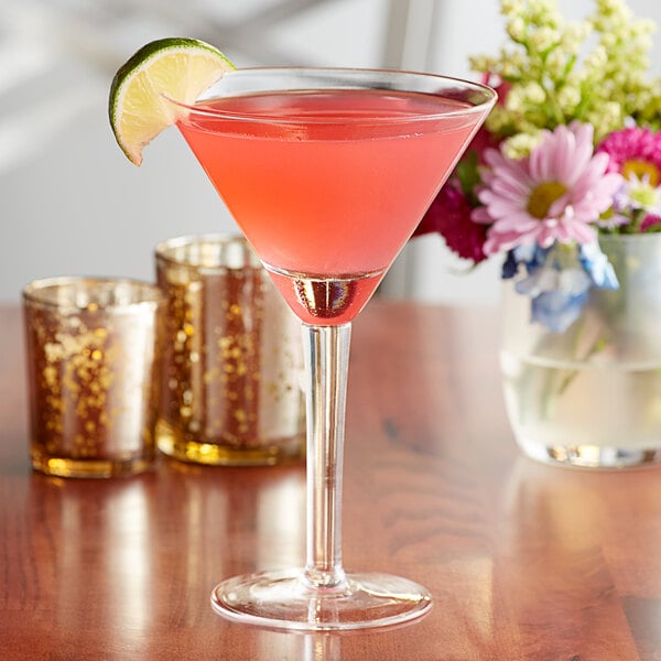 A close-up of a pink Marbeya martini in an Anchor Hocking cocktail glass with a lime slice on the rim.