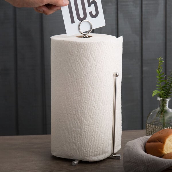 A hand using an American Metalcraft stainless steel curved wire paper towel holder with card holder.