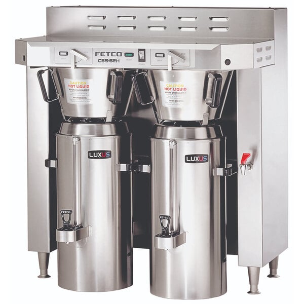 A stainless steel Fetco twin automatic coffee brewer with two large silver containers.