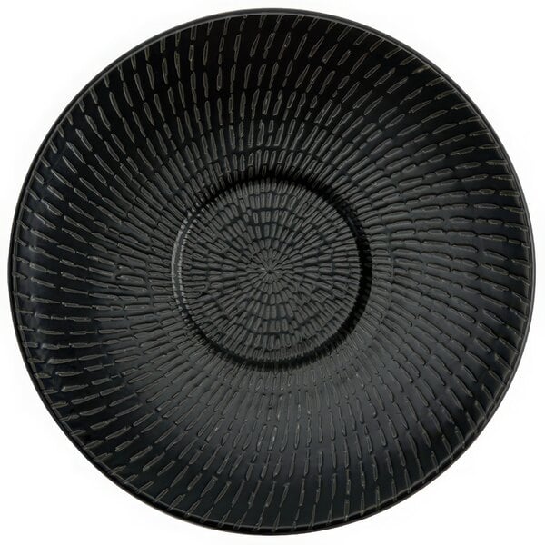 A black porcelain saucer with a circular design.