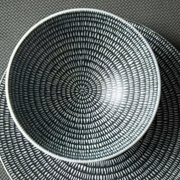 A white Luzerne porcelain bowl with a black and white circular design.