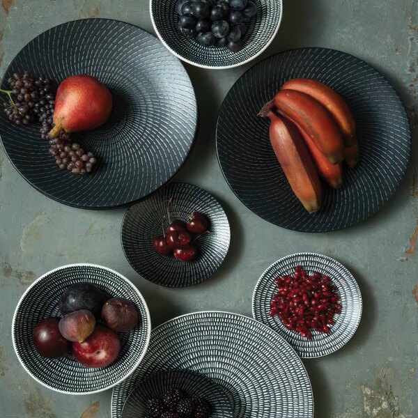 A Luzerne black porcelain coupe plate with fruit on it.