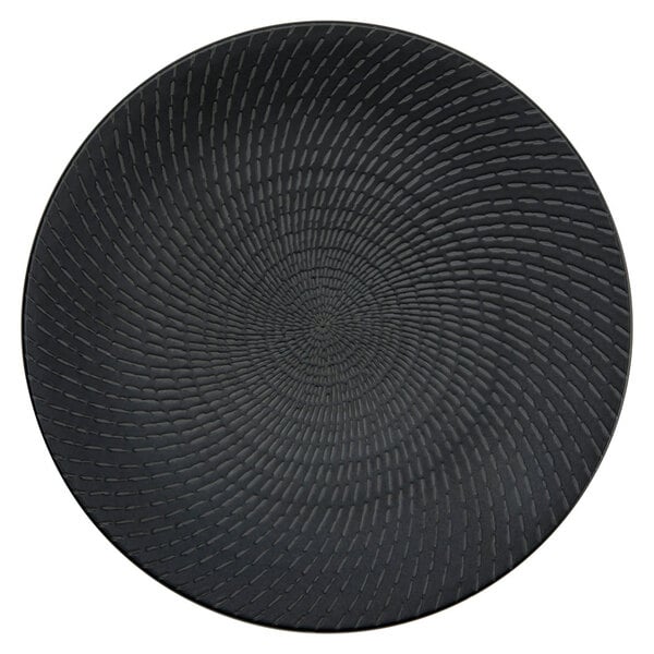 A close-up of a black Oneida Urban porcelain coupe plate with a circular spiral pattern.
