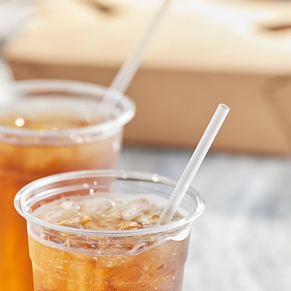 Two plastic cups of brown liquid with Choice jumbo straws.