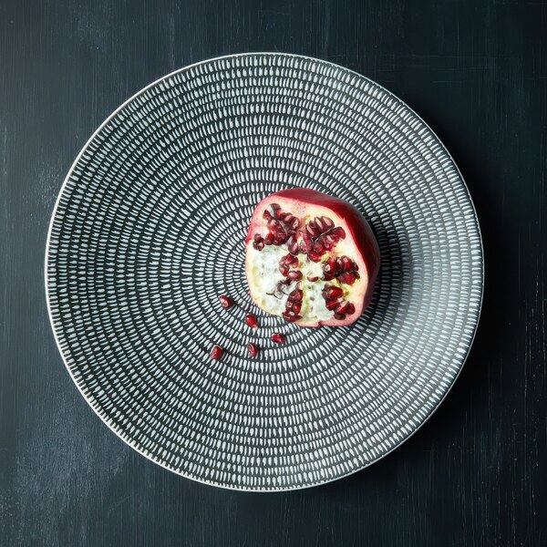 A Luzerne round porcelain coupe plate with a pomegranate on it.