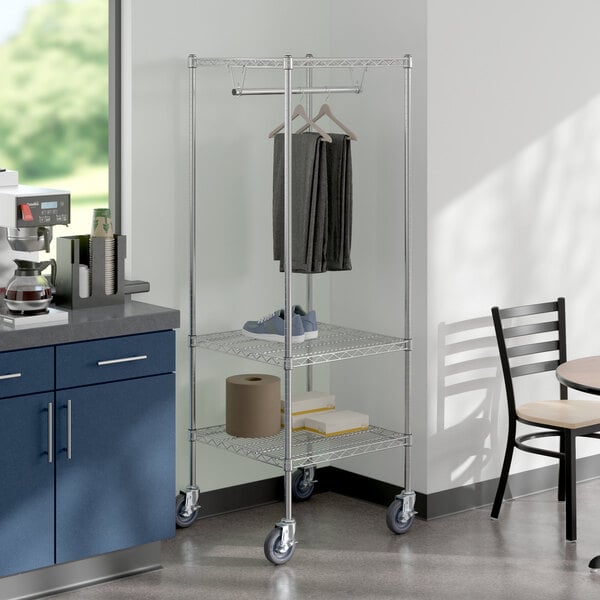 A chrome metal rack with clothes hanging on it.