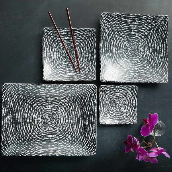A group of rectangular Oneida Urban Storm sushi plates on a table with chopsticks.