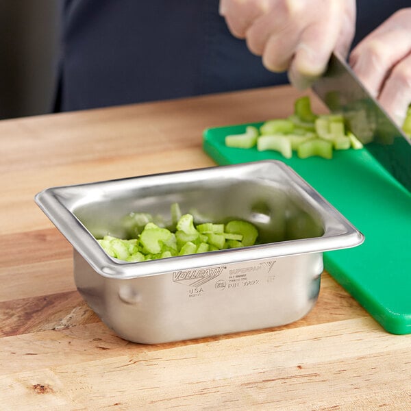 A metal container with chopped vegetables including celery and green bell pepper.
