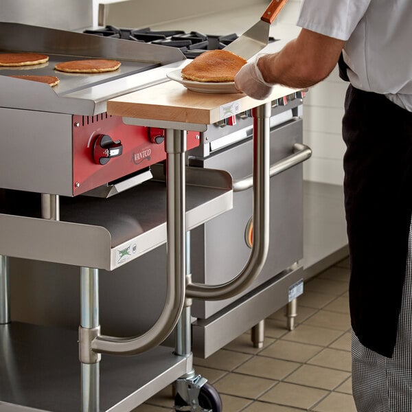 A person using a Regency wooden adjustable cutting board on a Regency equipment stand.