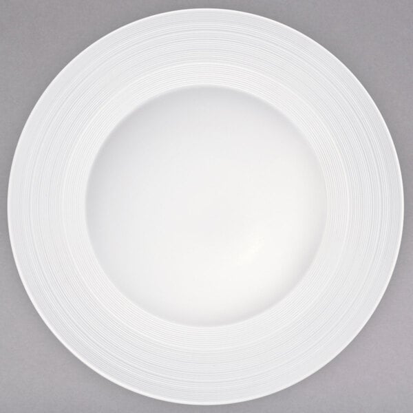 A Oneida warm white porcelain rim soup bowl with a circular pattern on the rim.