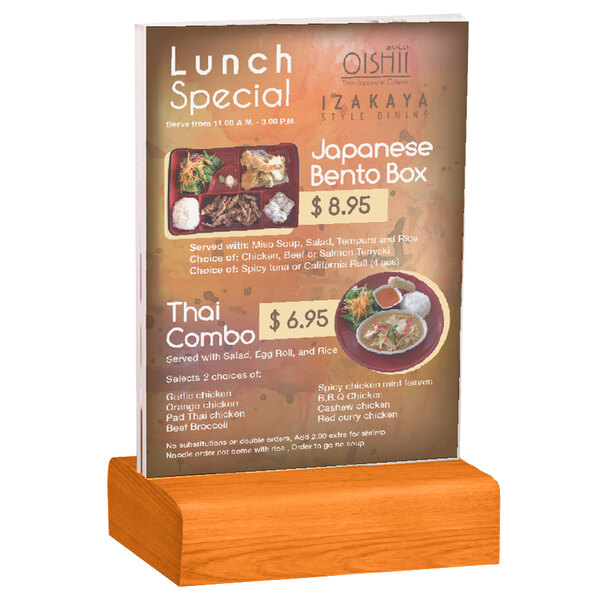 A Menu Solutions clear acrylic table tent on a solid wood stand holding a menu on a table.