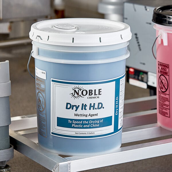 A close-up of a pink 5 gallon bucket of Noble Chemical Dry It HD+ liquid rinse.