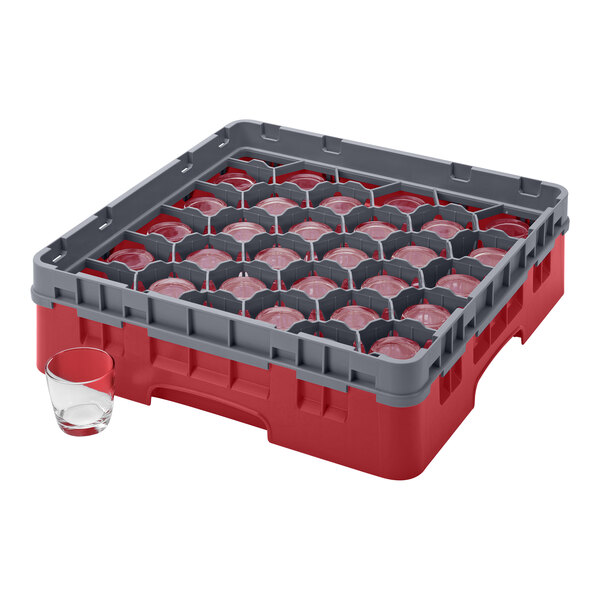 A red and grey plastic Cambro glass rack with a glass in it.