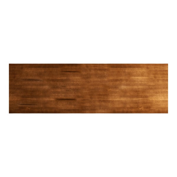A brown rectangular wood table top with a live edge and brown stain.
