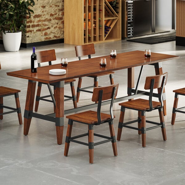 A rectangular wooden dining table with a rustic walnut finish, surrounded by matching chairs with metal accents, set in a modern dining area.