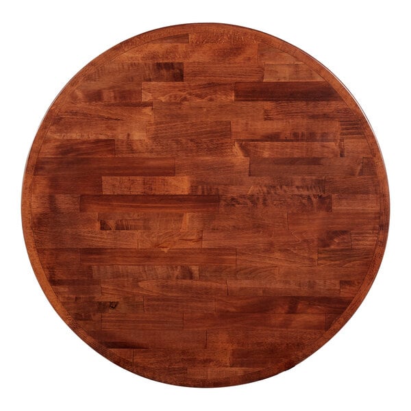 A Lancaster Table & Seating round wooden butcher block table top with mahogany finish.