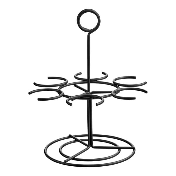 A black metal Vollrath flight carrier with six rings on a table.