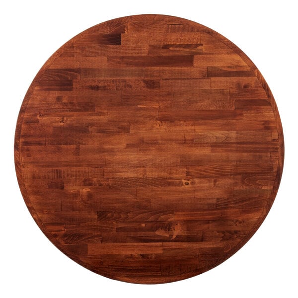 A Lancaster Table & Seating round wooden butcher block table top with a mahogany finish.